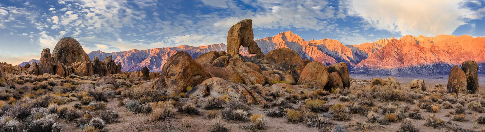 Rock arch and boulders with sunlit Sierra peaks, banner for couples therapy by telehealth